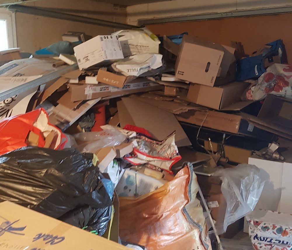 garage très encombré de carton et poubelles